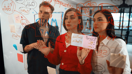 Young creative start up business team brainstorming idea and solving problems by using colorful sticky note and mind map at glass board, modern meeting room. discussing, working together. Immaculate.の写真素材