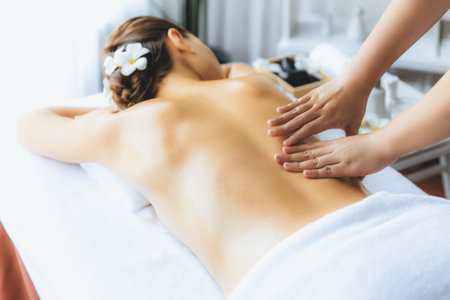 Caucasian woman customer enjoying relaxing anti-stress spa massage and pampering with beauty skin recreation leisure in day light ambient salon spa at luxury resort or hotel. Quiescentの写真素材