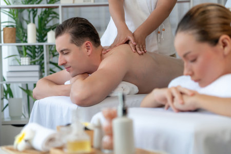 Caucasian couple customer enjoying relaxing anti-stress spa massage and pampering with beauty skin recreation leisure in day light ambient salon spa at luxury resort or hotel. Quiescentの写真素材