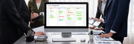 Panorama shot analyst team utilizing BI to analyze financial report with laptop. Businesspeople analyzing BI data dashboard displayed on laptop screen for business insight.の写真素材