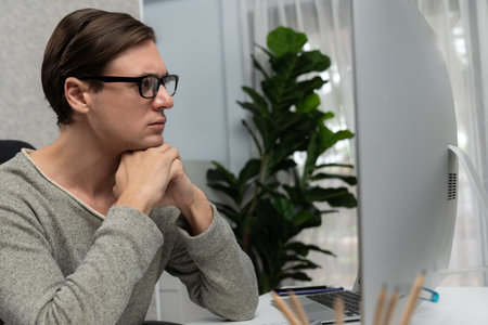 Stressful office worker concentrating on business report on pc, analyzing market strategy planning...