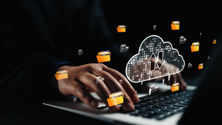 A close-up view of hands typing on a laptop with a cloud computing icon, illustrating modern data...