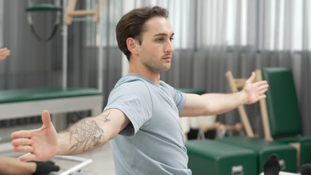 Two clients performing synchronized arm extensions on Pilates reformer machines. Happy pilates partner seated twist on the reformer for enhancing flexibility and building balance, control. Habituate.の写真素材