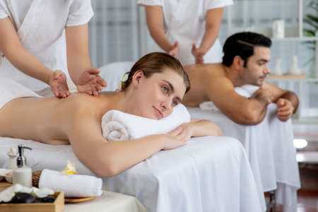 Caucasian couple customer enjoying relaxing anti-stress spa massage and pampering with beauty skin recreation leisure in day light ambient salon spa at luxury resort or hotel. Quiescentの写真素材