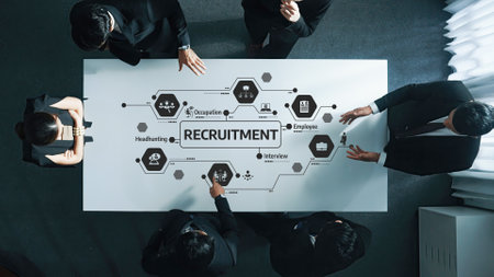 Dynamic Team Collaboration at Recruitment Table with Strategy Flowcharts and Icons for Job Roles and Interviews in Modern Office Setting.の写真素材