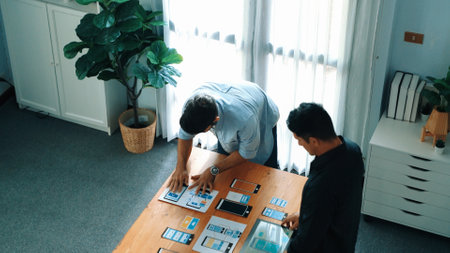 Top view of smart UI designer brainstorming and planning about UX UI design or mobile interface wireframe design with diverse development team. Caucasian programmer walking and joining meeting.の写真素材