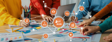 A diverse team collaborates in a bright workspace, engaging in brainstorming and digital planning,...