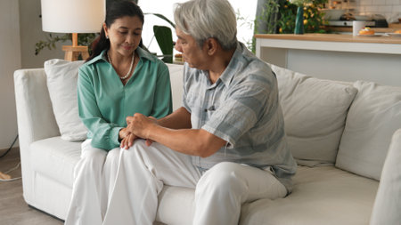 Stressed senior man with casual cloth having a headache while his wife encouraging and supporting by...