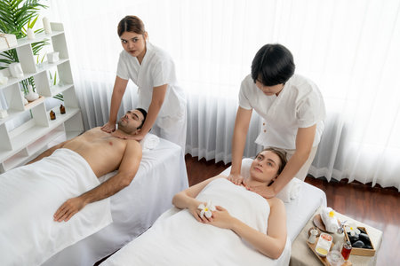 Caucasian couple customer enjoying relaxing anti-stress spa massage and pampering with beauty skin recreation leisure in day light ambient salon spa at luxury resort or hotel. Quiescentの写真素材