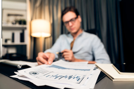 Smart businessman holding paperwork report paragraph dynamic database, looking at pc screen with...