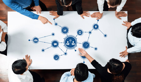 A diverse team collaborates in a modern office setting, engaging in discussion around a digital...