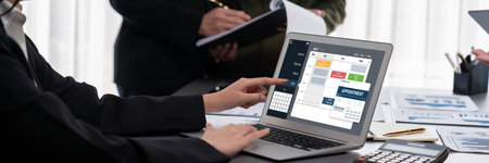 Panorama shot analyst team utilizing BI Fintech to analyze financial report with laptop. Businesspeople analyzing BI data dashboard displayed on laptop screen for business insight. Prodigyの写真素材