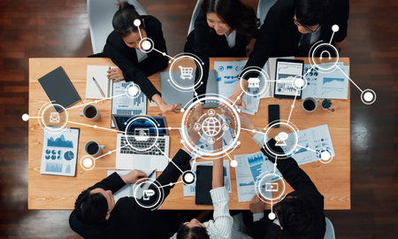 Diverse Business Team Collaborating in a Meeting Setting Surrounded by Data Visualizations and Digital Connectivity Icons on a Wooden Table. Amityの写真素材