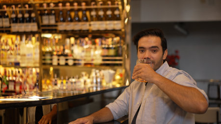 Smiling smart man drinking cocktail in Old fashioned with enjoy dancing in cheers with friends or...
