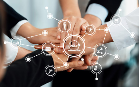Diverse hands coming together symbolize teamwork and agility in business. This image represents...