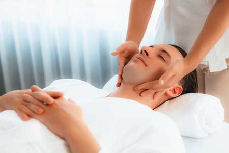 Caucasian man enjoying relaxing anti-stress head massage and pampering facial beauty skin recreation leisure in dayspa modern light ambient at luxury resort or hotel spa salon. Quiescentの写真素材
