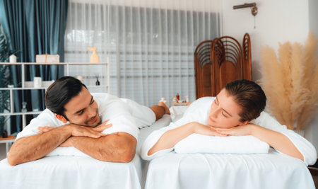 Caucasian couple customer enjoying relaxing anti-stress spa massage and pampering with beauty skin recreation leisure in day light ambient salon spa at luxury resort or hotel. Quiescentの写真素材
