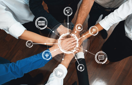 A dynamic image showcasing diverse hands joined in a circle, symbolizing teamwork and collaboration, complemented by digital communication icons representing innovation and strategy. Amityの写真素材