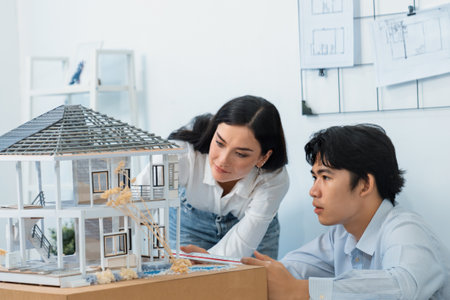 Portrait of cooperative engineer team working together to measure house model by using ruler and architectural equipment. Creative business design and teamwork concept. Immaculate..の写真素材
