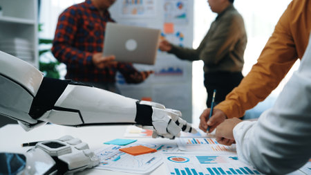 A robot arm extends to assist human colleagues in a modern office, embodying the synergy between technology and teamwork in creative projects and strategic discussions.の写真素材