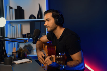 Host channel of smart influencer in creative audio on live streaming to fanclub with sing with play guitar music blogger using headset and mic social media online at neon light modern studio. Surmise.の写真素材