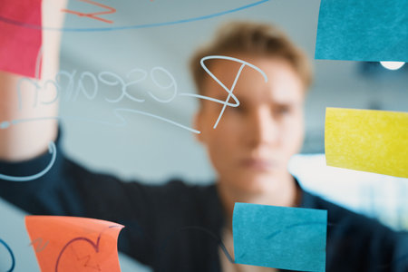 Professional caucasian businessman brainstorming marketing idea by using mind map and sticky notes...