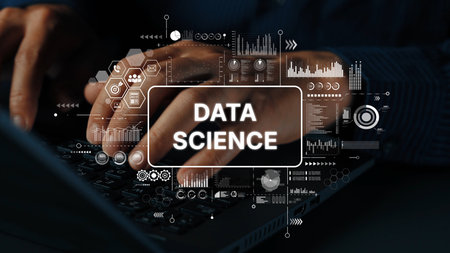 Hands typing on laptop keyboard with data science graphics and analytics interface in modern digital...
