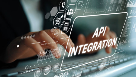 Business professional working on keyboard with API integration graphics and digital interface...