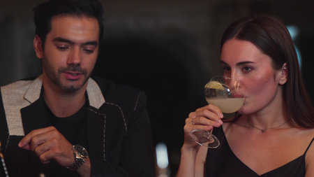 Beautiful woman zipping Margarita cocktail savoring sour tasty drink beside smart couple or friend...