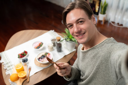 Smiling smart influencer making take photo selfie with healthy food yogurt toppings with berry fruit background, promoting with advertisement online for benefit of vitamin and fiber meal. Pecuniary.の写真素材