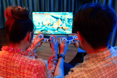 Couple gamer with controlled joystick playing fighting competition video game together on tv screen...