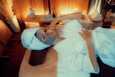 Serene ambiance of spa salon, top view woman customer indulges in rejuvenating with charcoal face...