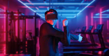 Asian man with VR glasses playing fitness while exercising at fitness. Male model using augmented...