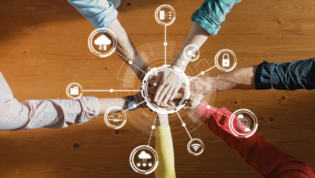 A vibrant display of teamwork and technology, showcasing diverse hands joining together amid digital...
