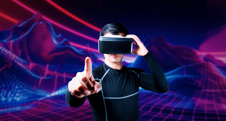 Smart asian man with bodysuit and pointing while standing at abstract background. Professional gamer...