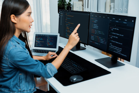 Young Asian girl of IT developer pointing online information on pc with coding program data...