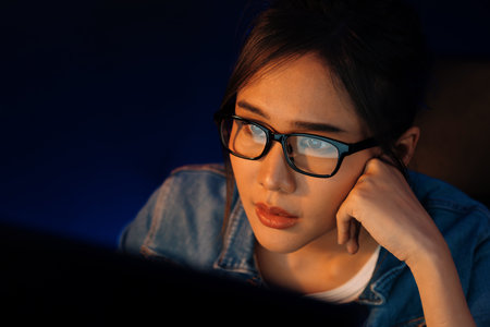 Portrait young beautiful Asian creative with glasses of serious face looking on pc to search project creator social media online, planning strategy creator at neon modern office at night. Stratagem.の写真素材