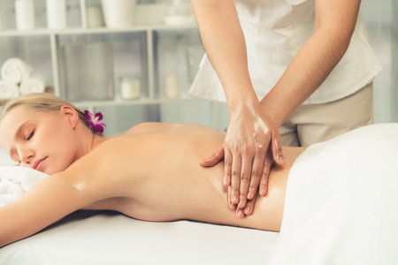 Caucasian woman customer enjoying relaxing anti-stress spa massage and pampering with beauty skin recreation leisure in day light ambient salon spa at luxury resort or hotel. Quiescentの写真素材