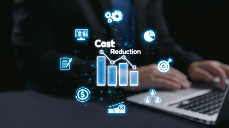 Businessman interacts with a laptop showcasing a virtual cost reduction graph while surrounded by digital financial icons, representing modern business strategies.の写真素材