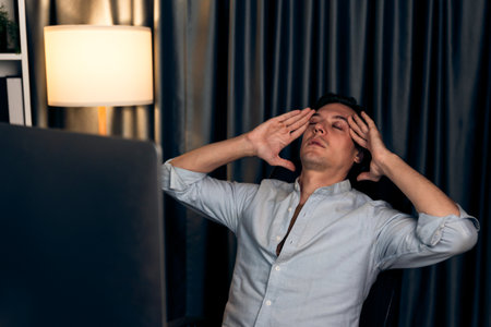 Thinking of stressful financial analyst researching on business paragraph on pc screen with dynamic database marketing analysis planning monthly report at modern home office at night time. Pecuniary.の写真素材