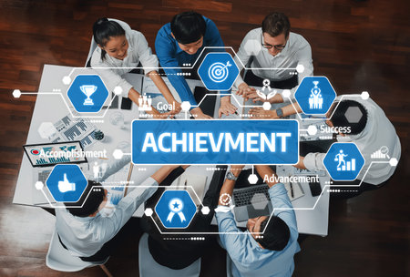 An overhead view of a diverse team engaged in a collaborative meeting, surrounded by icons representing goals, success, and professional achievement in business context. Amityの写真素材