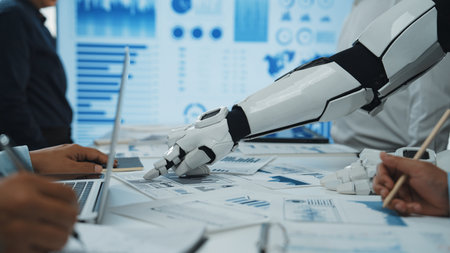 A futuristic robotic hand interacts with human colleagues in a sleek workspace, showcasing collaboration through data presentation and analysis with charts and graphs.の写真素材
