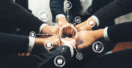 A diverse group of professionals in business attire unite their hands in a collaborative display,...