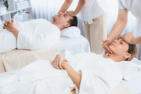 Caucasian couple enjoying relaxing anti-stress head massage and pampering facial beauty skin...