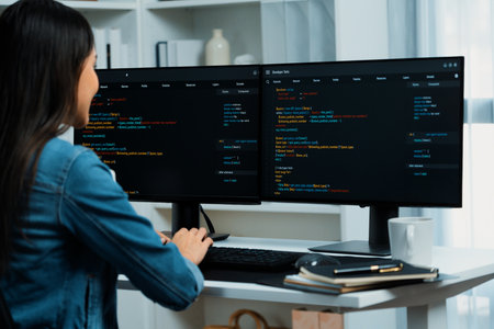 Young Asian in IT developer creating with typing online information on pc with coding program data of website application, wearing jeans shirt. surrounded by safety analysis two screens. Stratagem.の写真素材