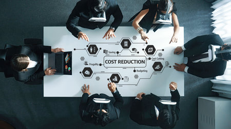 A diverse group of professionals engage in a strategic meeting focused on cost reduction and budgeting, fostering collaboration in a modern office setting.の写真素材