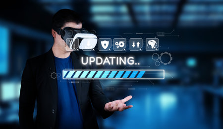 A man in a virtual reality headset stands in a modern environment, engaging with digital elements. The image showcases an updating process, symbolizing technology advancement.の写真素材