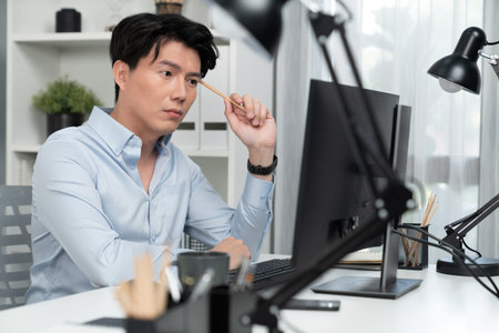 Serious smart businessman working on computer to check email with business project report, analyzing on market shares customer database in casual day at modern office in startup concept. Infobahn.の写真素材
