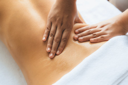 Closeup woman customer enjoying relaxing anti-stress spa massage and pampering with beauty skin recreation leisure in day light ambient salon spa at luxury resort or hotel. Quiescentの写真素材