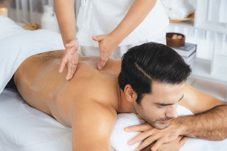 Caucasian man customer enjoying relaxing anti-stress spa massage and pampering with beauty skin recreation leisure in day light ambient salon spa at luxury resort or hotel. Quiescentの写真素材